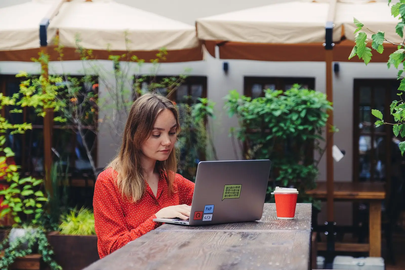 Une personne qui travaille sur son ordinateur à une terrasse de café