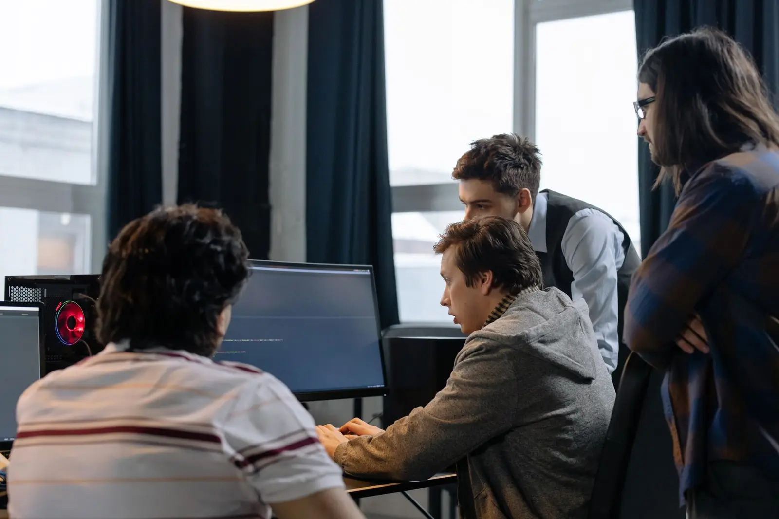 Une équipe logicielle réunie autour d'un écran dans un open space